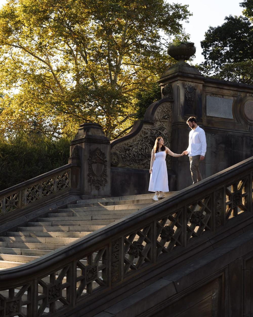A couple holding hands on the Bethesda Terrace steps in Central Park