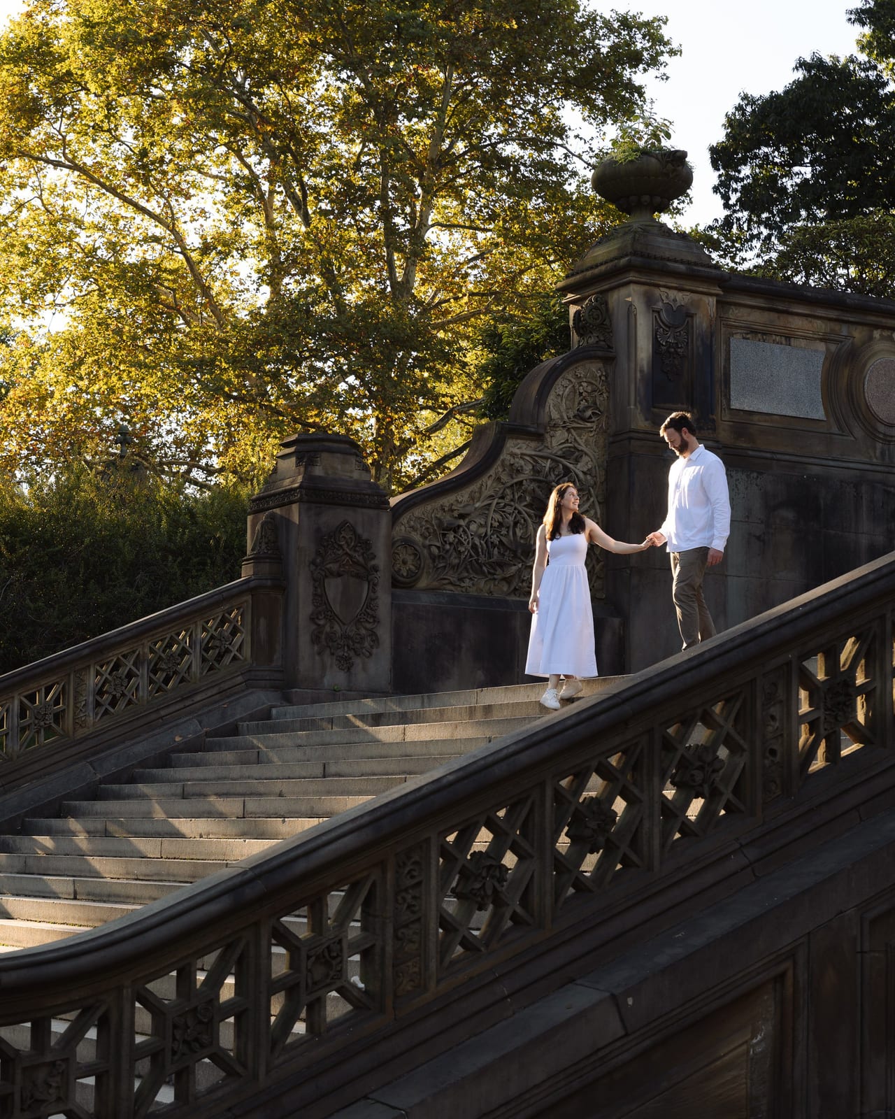 A couple holding hands on the Bethesda Terrace steps in Central Park