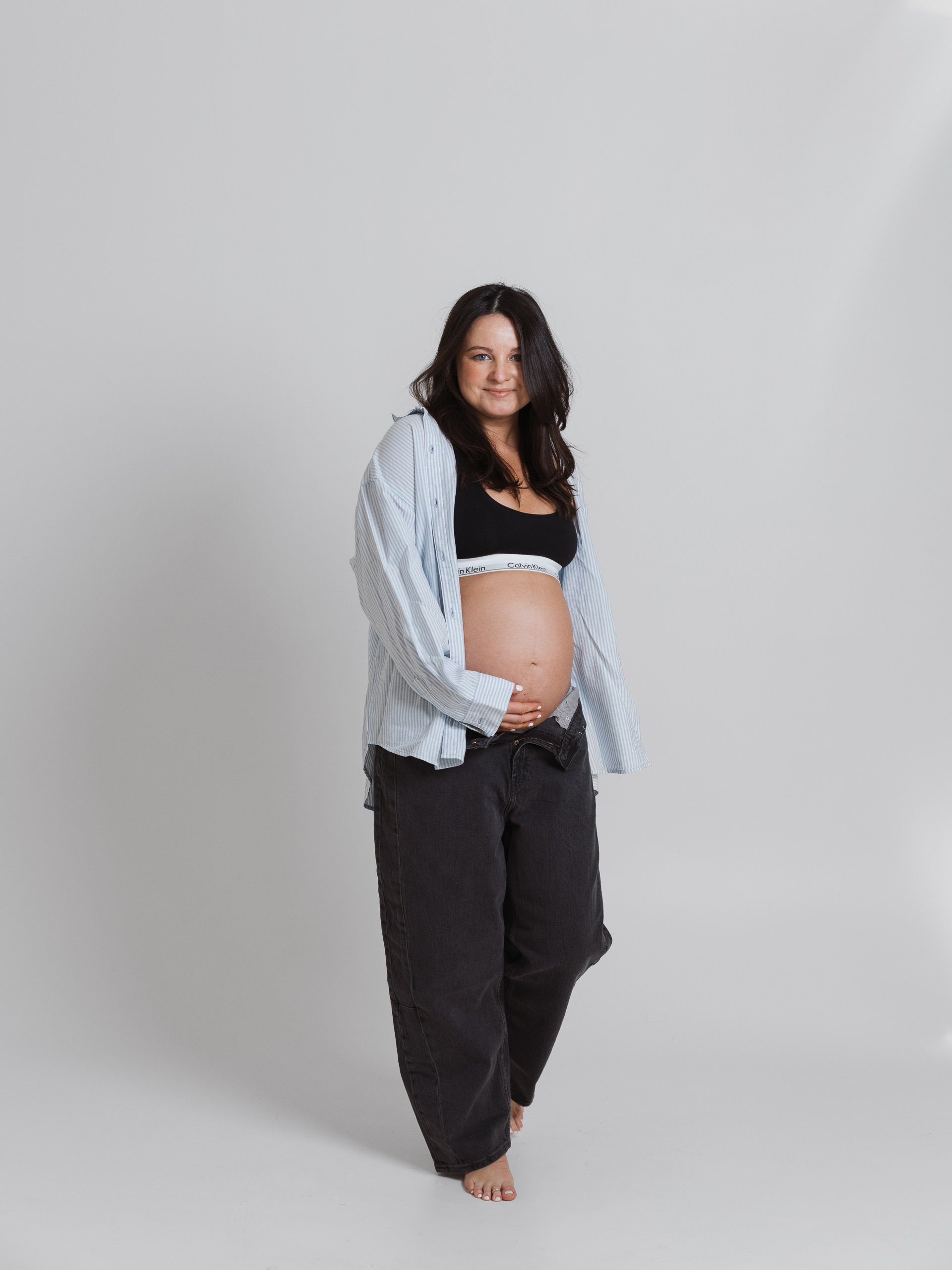 A maternity portrait in a bright studio